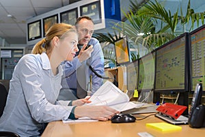 two co-workers discussing papers in tv studio