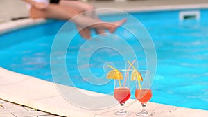 Two cocktails on the background of pool with girls