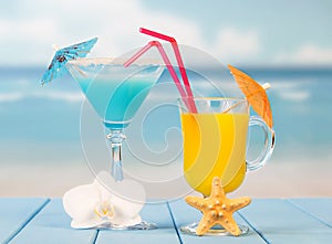 Two cocktails with umbrellas close up on background of the sea