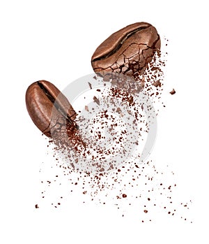 Two coffee beans broken into powder close-up on a white