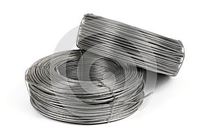 Two coils of galvanized wires lying on white background