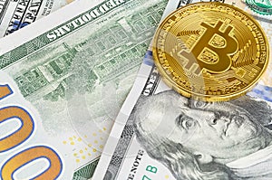 Two coins of bitcoin on banknotes of one hundred dollars. Exchange bitcoin cash for a dollar