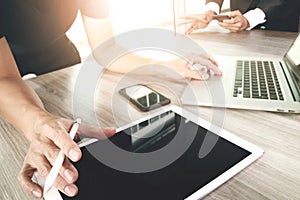 two colleagues businessman discussing data and blank screen digital tablet and computer laptop with smart phone on wooden desk as