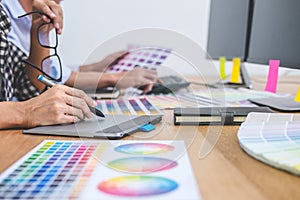 Two colleagues creative graphic designer working on color selection and drawing on graphics tablet at workplace, Color swatch