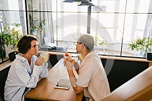 Two colleagues discussing business details during coffee break