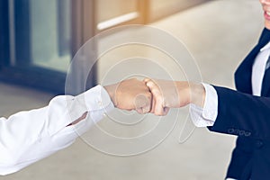 Two colleagues doing fist bump celebrate finish project