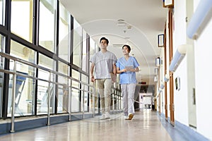 Two colleagues of nursing home walking in hallway