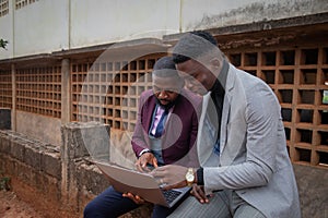 Two colleagues working an a project together look at a laptop screen, synergy and work together concept