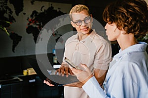 Two colleagues working together and discussing business details in office