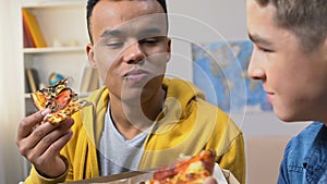 Two college friends enjoying fresh pizza slices, high calorie meal free delivery