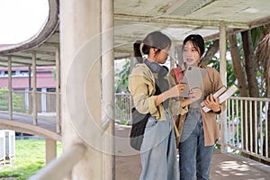 Two college student female friends smile ready for class at the university campus