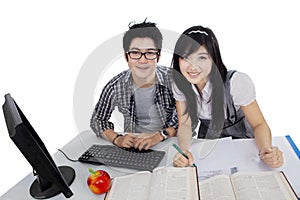 Two college student learn on table