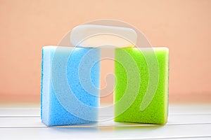 Two colored sponges and white soap for cleaning
