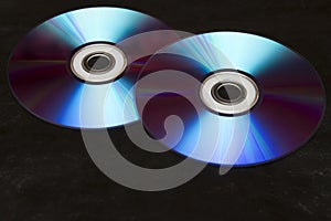 Two colorful CDs on a black background