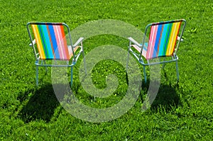 Two colorful chairs standing on grass