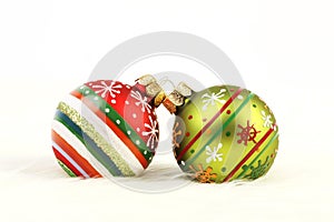 Two colorful Christmas balls on white fur background