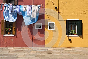 Two colorful houses of Burano Island with laundry, Venice, Italy