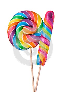 Two colorful lollipop swirl spiral big candies on wooden stick rainbow colored isolated on white