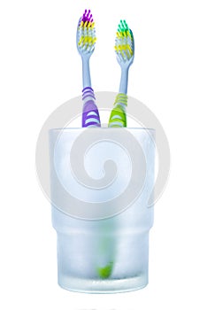 Two colorful toothbrushes in glass