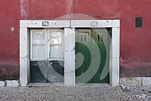 Two colorful wooden doors to a building in Lisbon