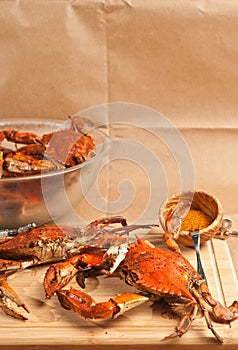 Two colossal steamed and seasoned chesapeake blue claw crabs on a wood cutting board