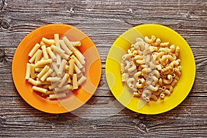 Two colour plates with pasta on a wood background