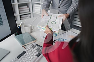 Two company employees handing over papers to each other, marketing staff handing over marketing analysis papers to department