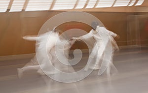 Two competitors fight using swords doing fencing, Madrid, Spain