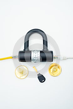 Two computer network cables going through a lock with a key and a crypto currency coin