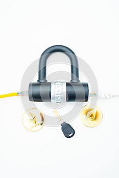 Two computer network cables going through a lock with a key and a crypto currency coin