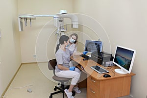 Two concentrated dentists looking at x-ray on computer