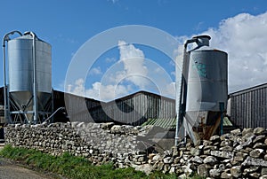 Two Cone shaped grain silo/hoppers on a farm