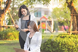 Two confidence business woman working together in a park outd