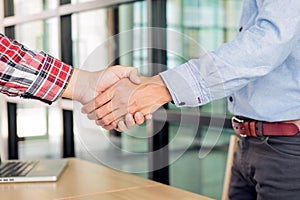 Two confident business man shaking hands during a meeting in the office, success, dealing, greeting and partner concept