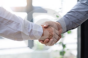 Two confident business man shaking hands during a meeting in the office, success, dealing, greeting and partner concept