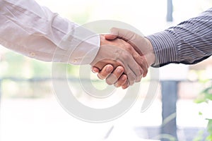 Two confident business man shaking hands during a meeting in the office, success, dealing, greeting and partner concept