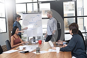 Two confident business people giving a presentation together over whiteboard with multi-ethnic colleagues of co-workers, Teamwork