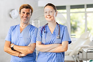 Two confident experienced doctor colleagues standing in medical office