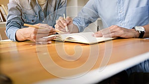 Two confident students doing homework together while sitting at the home or class room