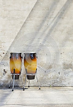 Two congas in front of a vintage wall