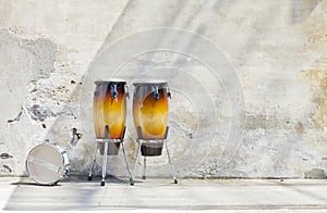 Two congas in front of a vintage wall