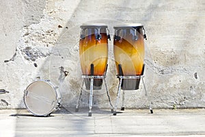 Two congas in front of a vintage wall