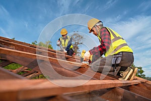 Two construction worker install new roof, Roofing tools, Electric drill used on new roofs of wooden roof structure, Teamwork