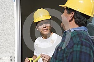 Two Construction Workers Checking Window