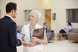 Two Consultants Discussing Patient Notes In Hospital