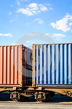 Two containers on a freight train parked in a rail terminal