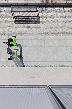 Two cops patrolling city streets wearing black uniforms and vests