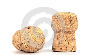 Two corks of champagne over a white background