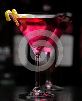 Two cosmopolitan drink in bar on black background