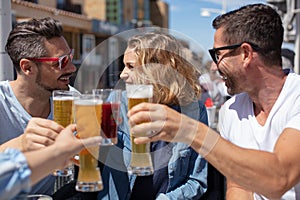 Two couples chinking glasses in outside bar